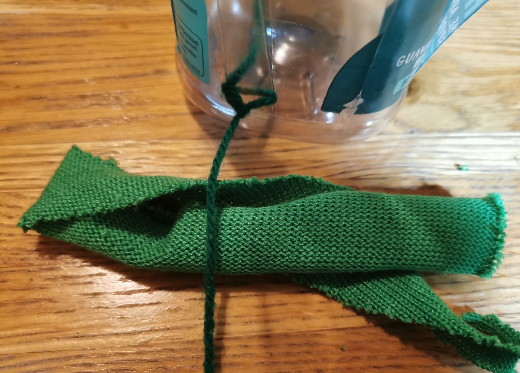 Tying fabric strip to yarn.